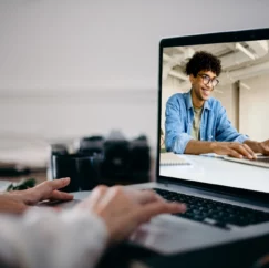 Smiling Man using Laptop, viewed from another laptop